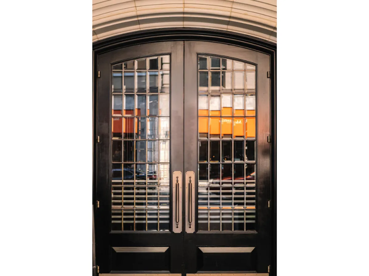 This image presents the hotel’s ornate double doors with intricate glasswork and brass handles, providing a sophisticated and welcoming entrance. The exterior view hints at the curated experience and boutique hospitality awaiting inside, setting the stage for business travelers seeking convenience and professionalism.